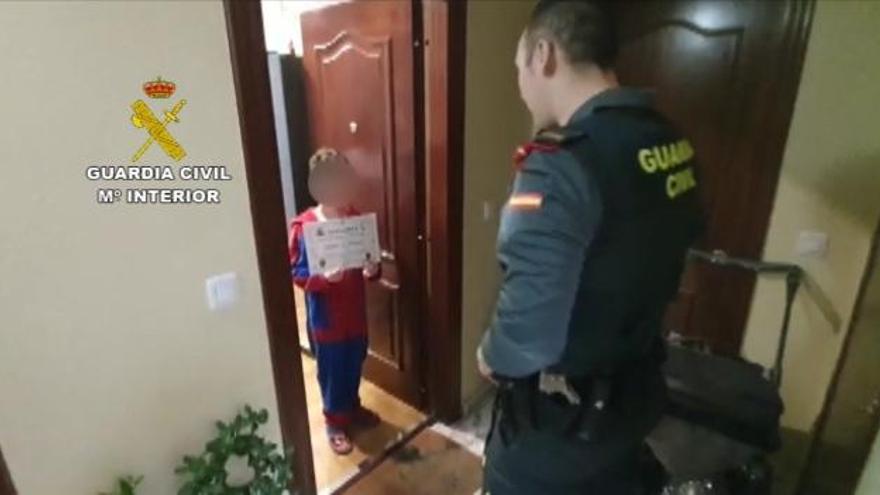 Un niño de Laviana recibe con un plato de galletas a la guardia civil que le lleva sus medicamentos