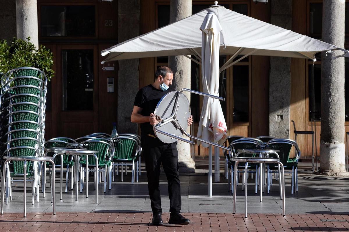 Un operario limpia el escaparate de una tienda en Valladolid este martes. 