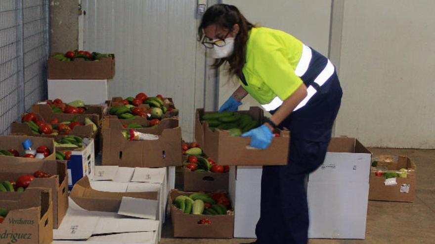 Una mujer traslada una de las cajas de alimentos que se repartieron.