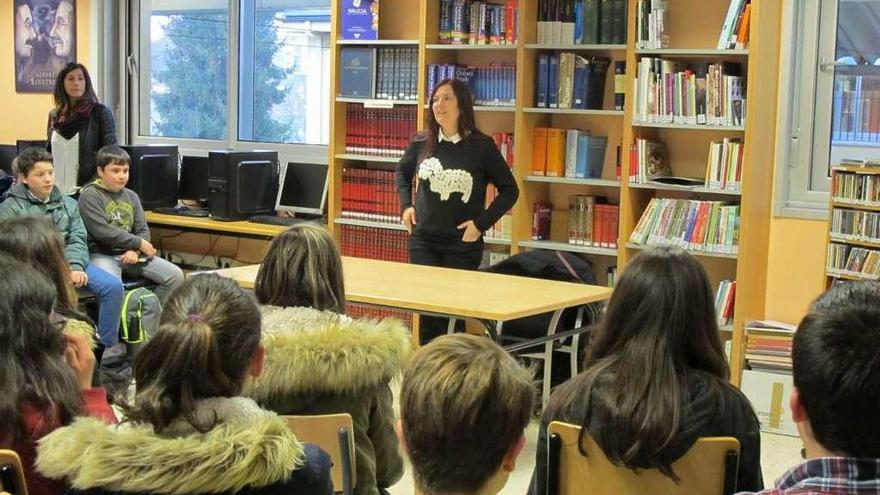 La escritora Ledicia Costas con alumnos en la biblioteca del IES Ramón Mª Aller Ulloa, de Lalín. // FdV