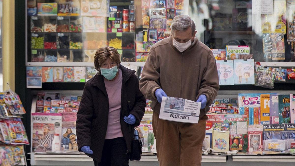 Una pareja pasea tras comprar un diario en un quiosco, el pasado abril, en pleno confinamiento, en València