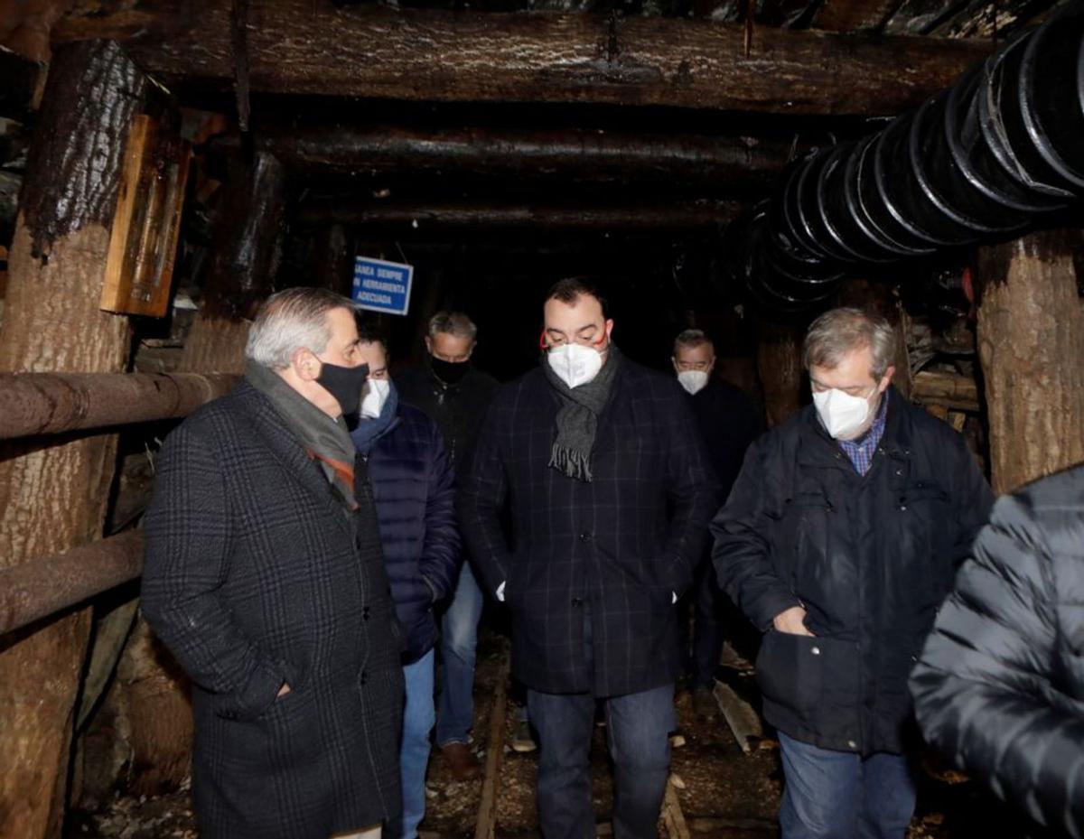 Por la izquierda, Aníbal Vázquez, Adrián Barbón y Gregorio Rabanal, en la bocamina de la Rabaldana, restaurada por el grupo Santa Bárbara. | F. R.