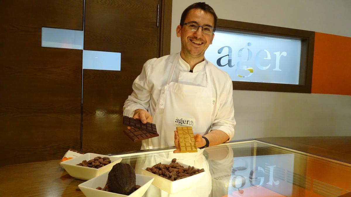 Miquel Viñolas amb algunes de les rajoles de xocolata al taulell de la botiga de Moià