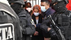 La ex presidenta interina de Bolivia, Jeanine Áñez (C), es escoltada por miembros de la policía de la Fuerza Especial contra el Crimen (FELCC) tras ser arrestada en La Paz, el 13 de marzo de 2021.