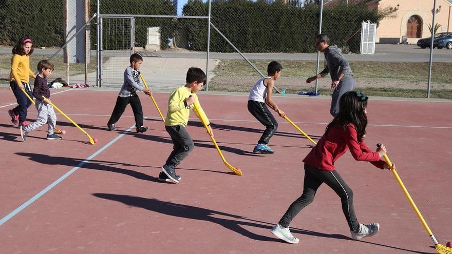 Varios niños juegan al hockey en un colegio.juan caballero