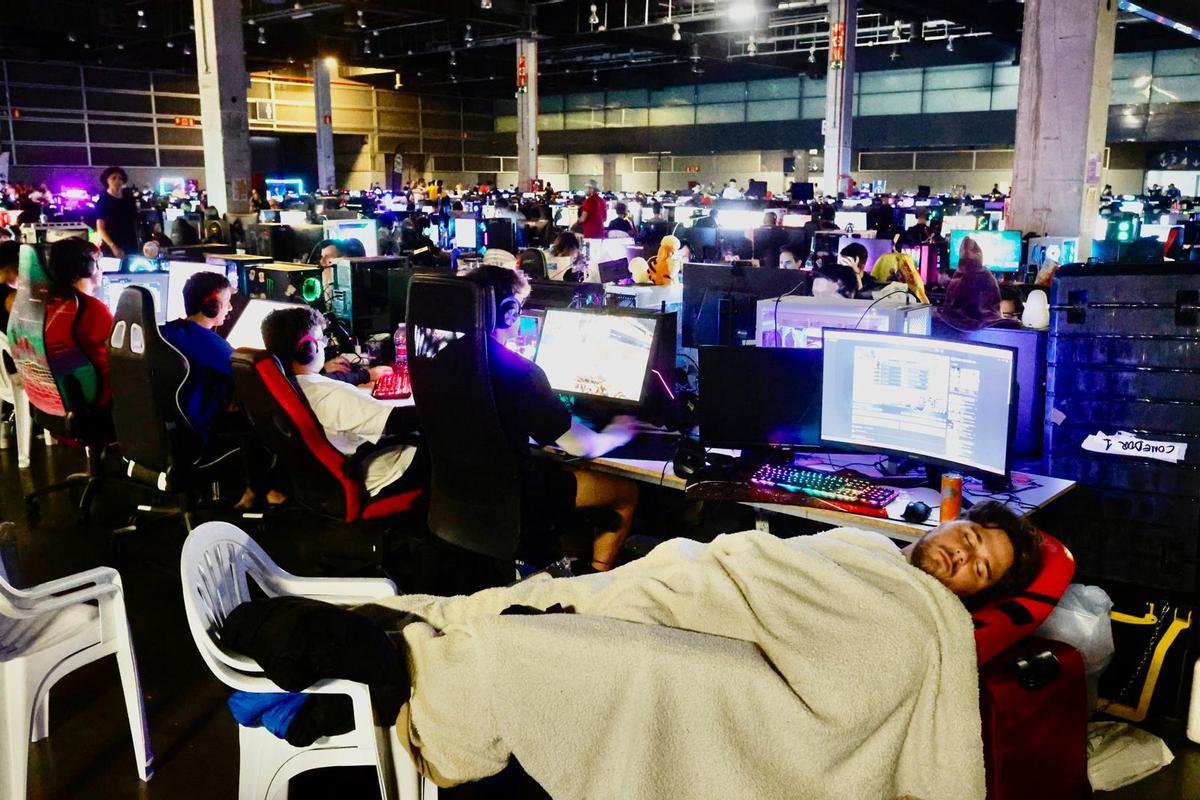 Un jugador descansa junto a su ordenador en la LAN Party.