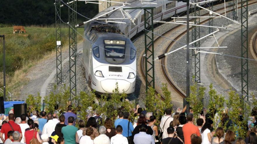 Familiares de las víctimas observan el paso de un tren en Angrois.