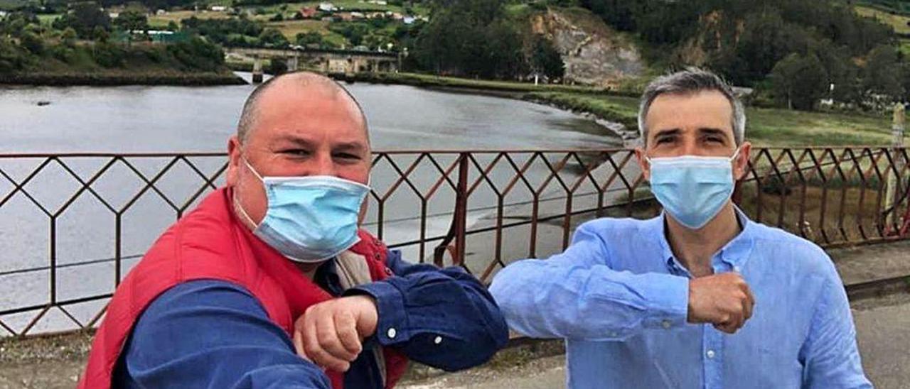 César Álvarez, &quot;Mourelle&quot;, y Fernando Suárez se saludan con el codo en el puente de Porto, limítrofe entre Vegadeo y Ribadeo, sobre el río Eo.