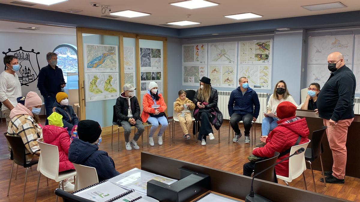 Les famílies de refugiats d'Ucraïna que han arribat a Llívia (Cerdanya), reunides a l'ajuntament amb l'alcalde, Elies Nova, membres dels serveis socials i persones que els han ajudat en la seva acollida.