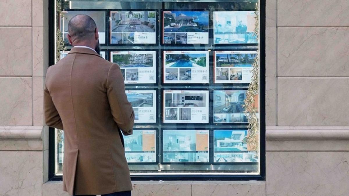 Una persona observa los anuncios en el escaparate de una inmobiliaria en Málaga.