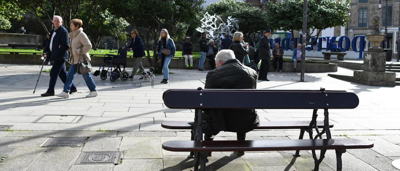 Un hombre de avanzada edad descansa en un banco en A Ferrería.