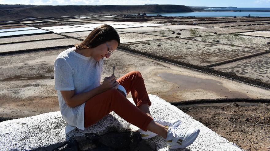 La escultora Cintia Machín trabaja en una de sus piezas en el exterior de su taller junto a las Salinas de Janubio