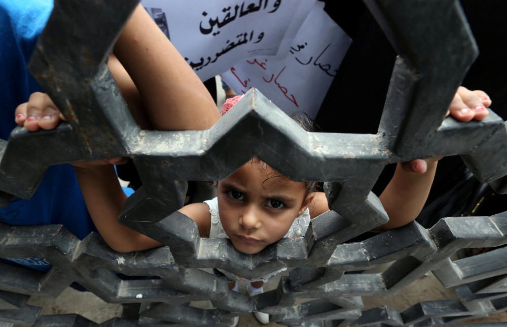 Niña palestina mira a través de la puerta del cruce fronterizo de Rafah entre Egipto y Gaza durante una protesta pidiendo a las autoridades egipcias que abran el cruce en el sur de la Franja de Gaza