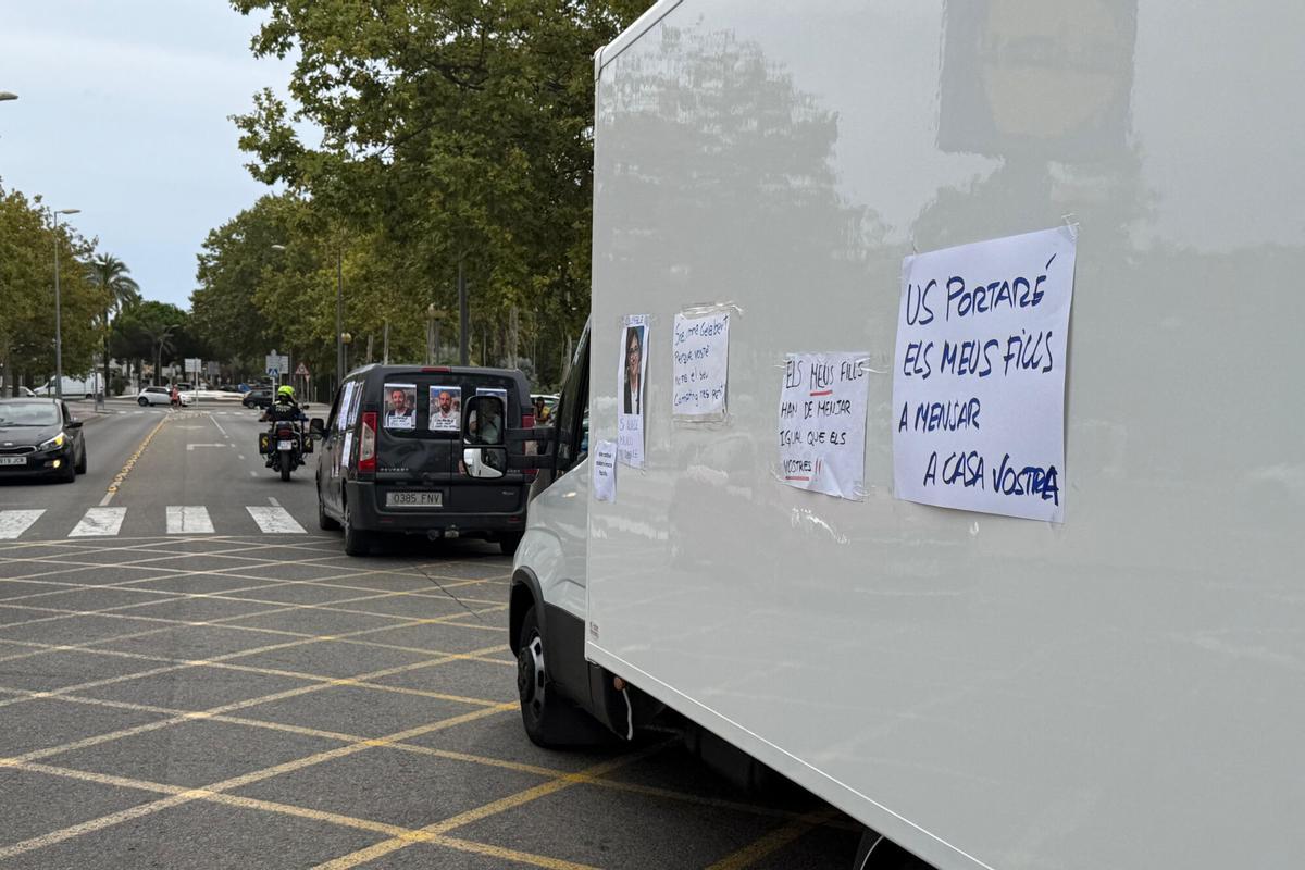 Dos vehicles plel centre de Platja d'Aro amb cartells protestant