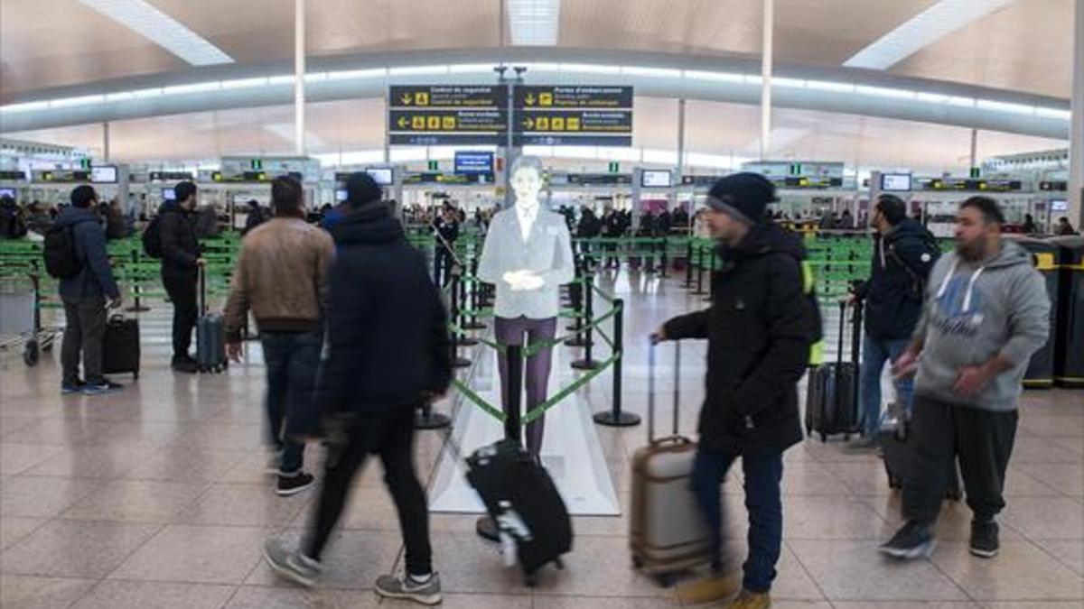 Varios pasajeros se dirigen al control de seguridad antes de embarcar, ayer, en la T-1 del aeropuerto de El Prat.