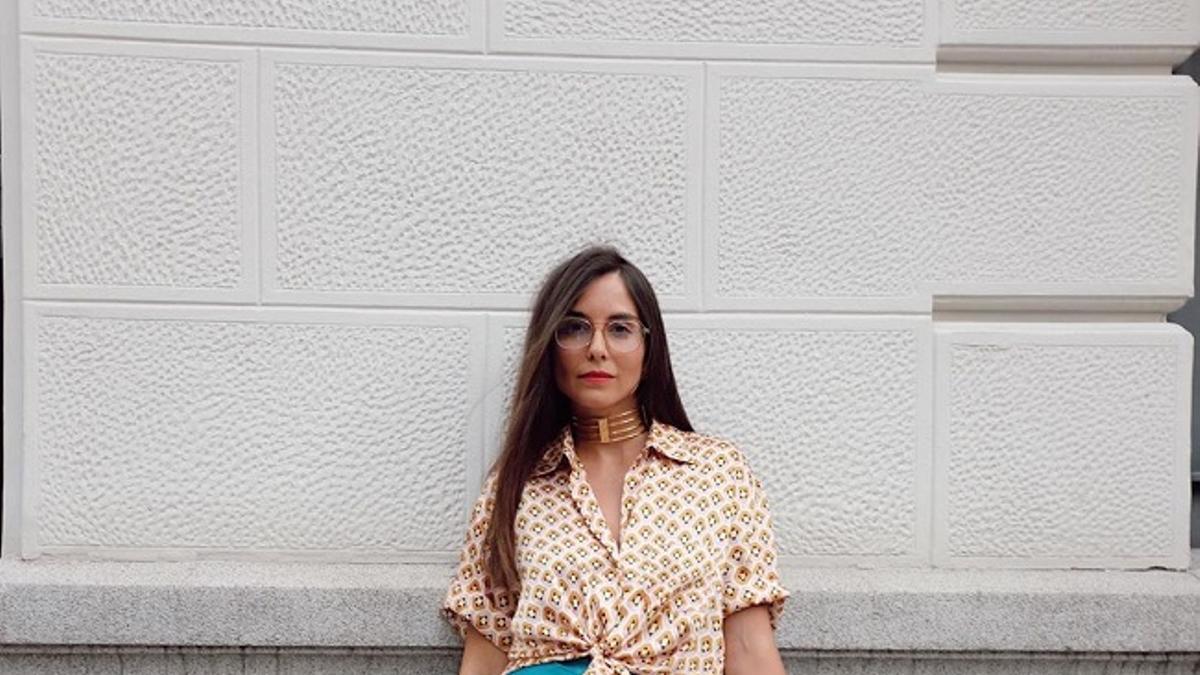 La estilista Erea Louro con falda azul satinada de las rebajas de Zara, camisa estampada y sandalias naranjas