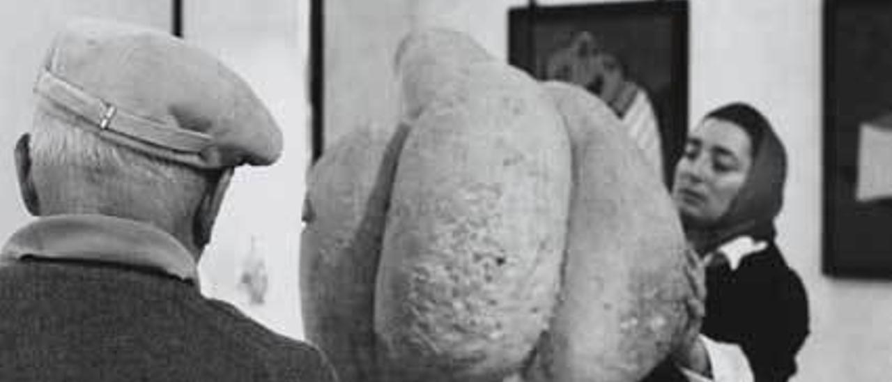 Picasso, de espaldas y con gorra, en una visita al museo de Antibes.