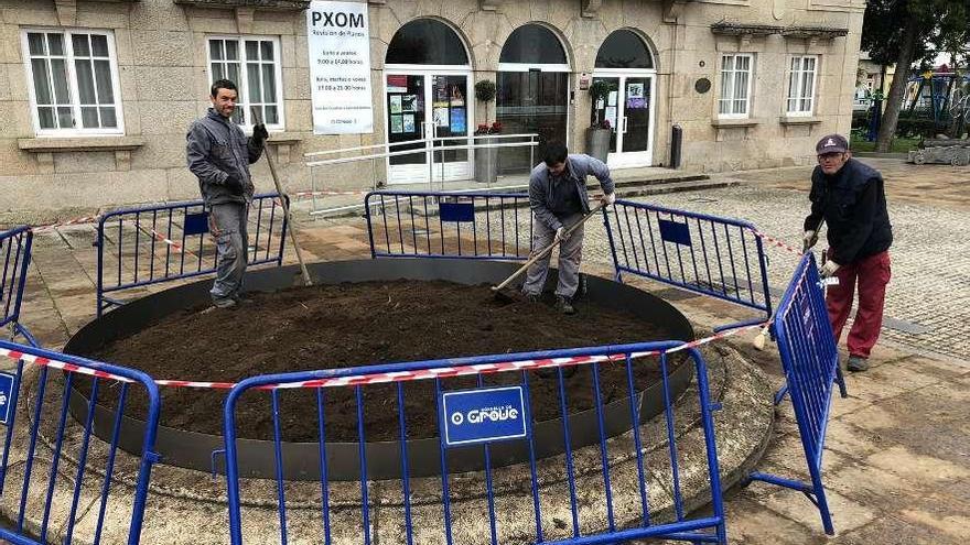 Trabajadores de la asociación Bata durante la instalación de las jardineras, en O Corgo. // Muñiz