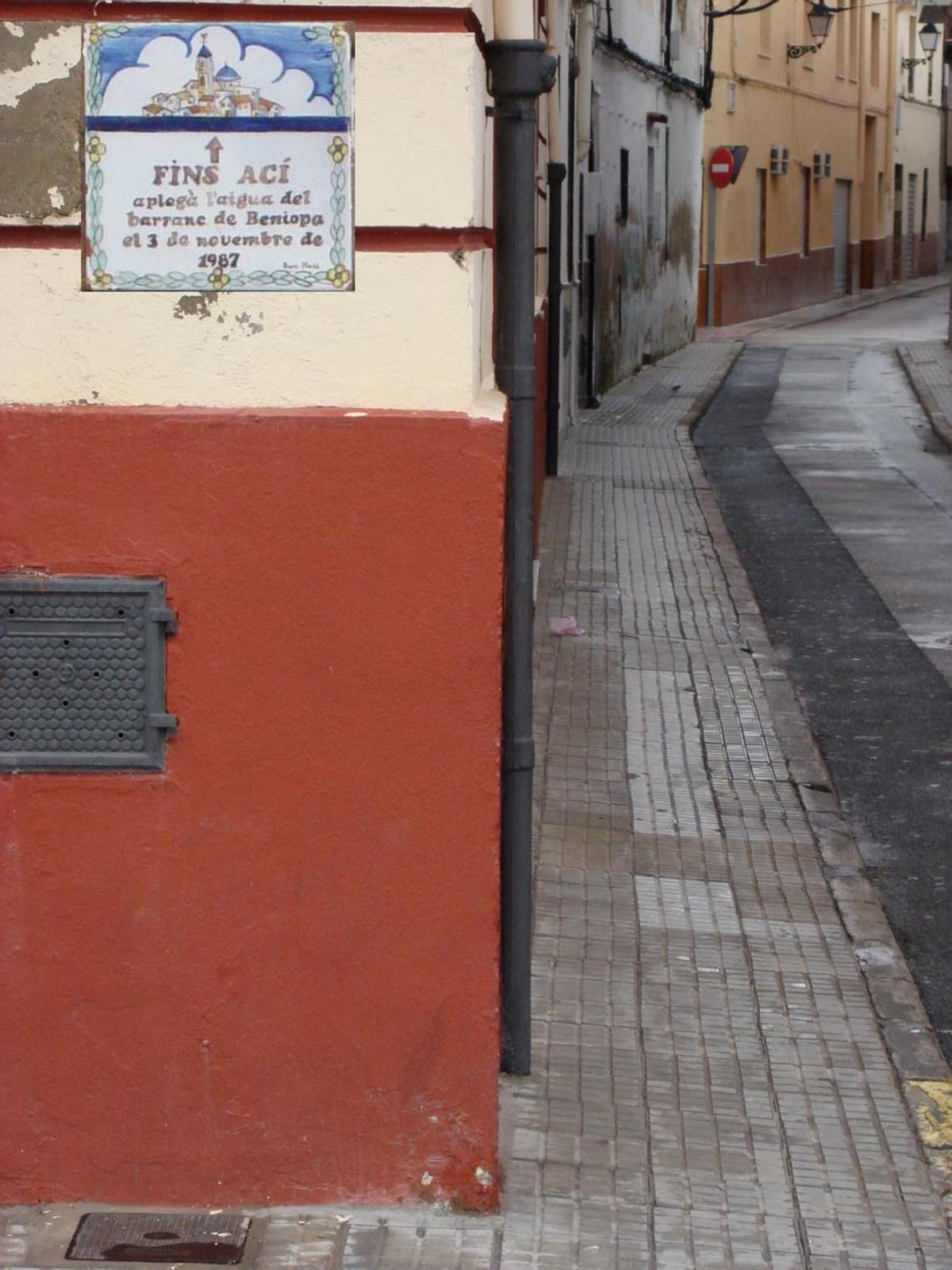 Una calle de Beniopa, con la cerámica que indica hasta dónde llegó el agua el 3 de noviembre de 1987.