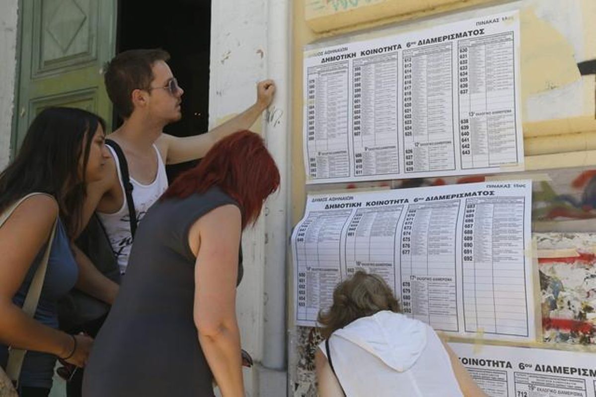 Diversos joves consulten la taula en què han de votar, avui a Atenes.