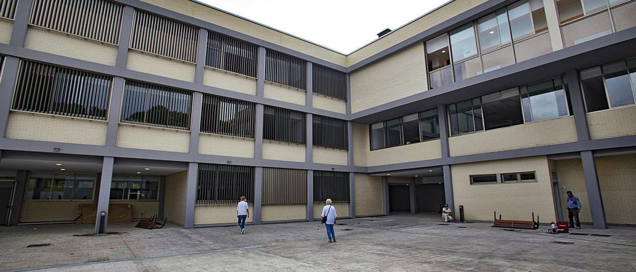 Obreros y profesores realizan los últimos retoques en la escuela, en una imagen de ayer | PERALES IBORRA