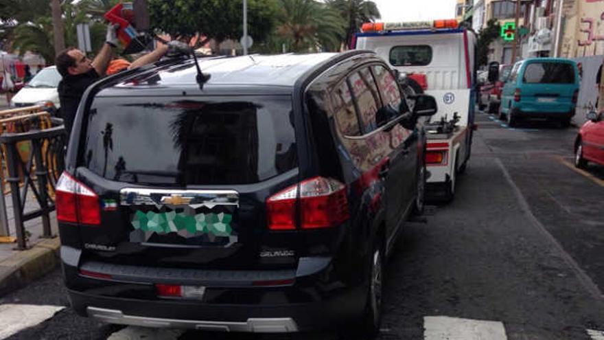 Momento en el que la grúa municipal engancha el vehículo consular.