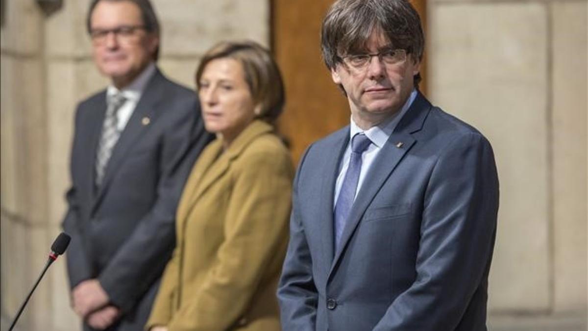 Carles Puigdemont, junto a Carme Forcadell y Artur Mas, en la toma de posesión de los 'consellers' del Govern.