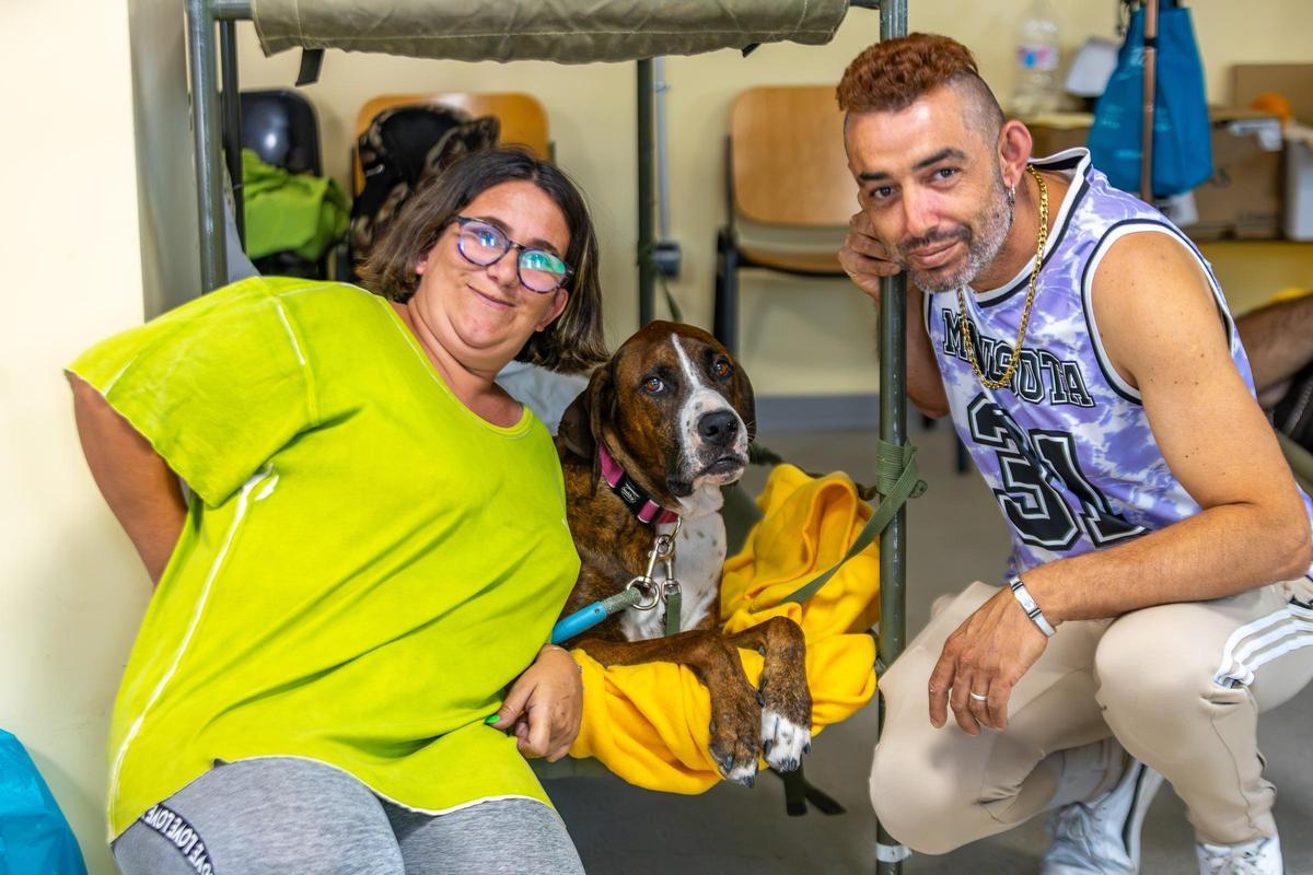 Cristian y Jennifer junto a su perro en el polideportivo de Villamanta.