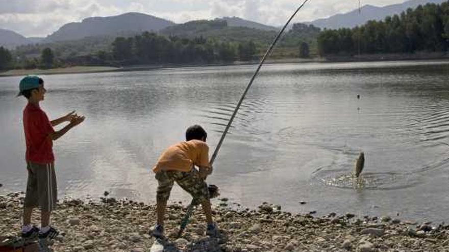 Dos niños pescando en las aguas del pantano de Beniarrés.