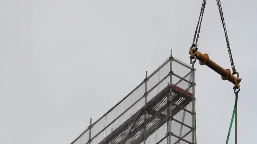 Dos operarios, en los trabajos para desmontar la cubierta de las tolvas de Pola de Laviana.