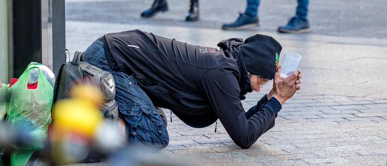 Una persona pide dinero en la vía pública, en una imagen reciente