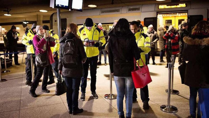 Agentes de seguridad comprueban la identidad de los pasajeros en la estación de tren de Copenhague. // Efe