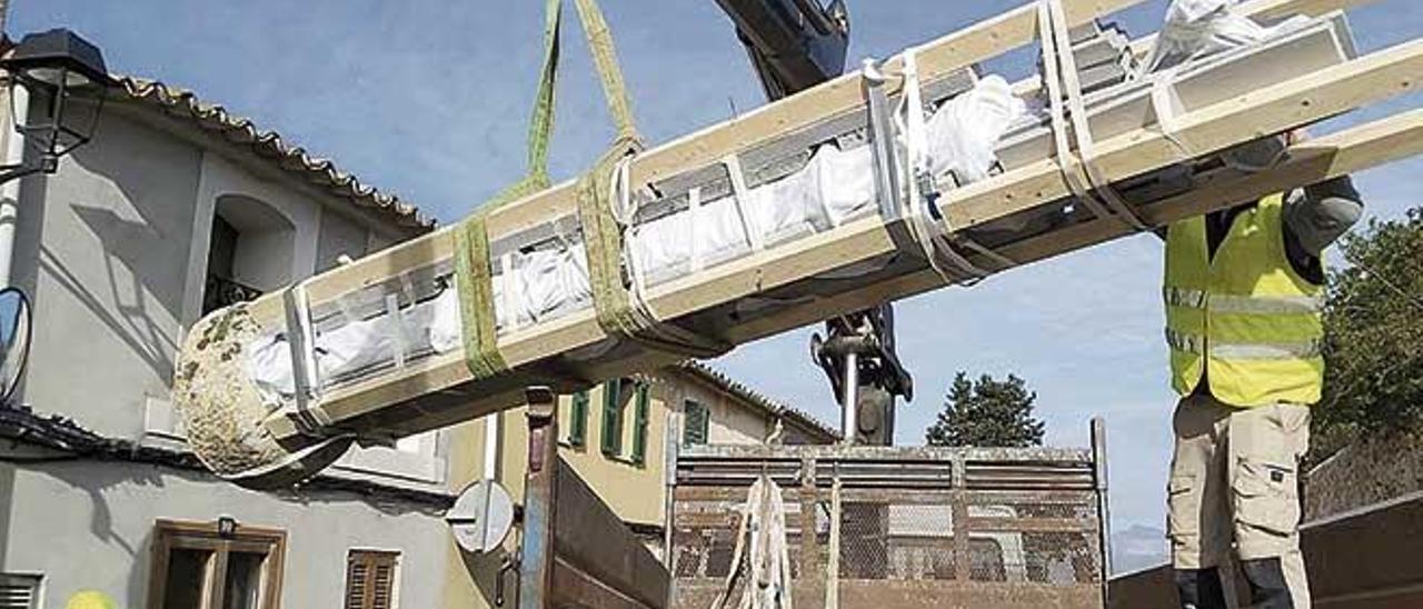 Momento en el que los operarios cargan la Creu de sa Cometa sobre el camiÃ³n para transportarla al lugar de la restauraciÃ³n.