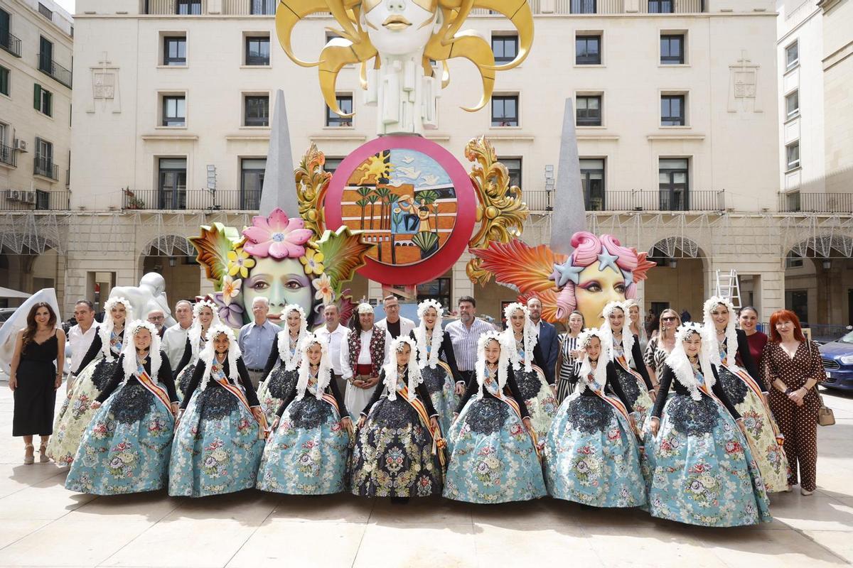 Foto de familia de los representantes de los municipios que han acudido a la visita a la Hoguera Oficial con la corporación municipal y las Belleas del Foc