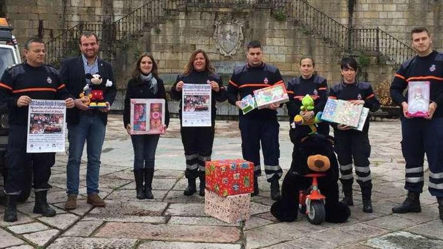 Voluntarios de Protección Civil de Piloña presentan junto a autoridades locales el cartel de la campaña de recogida de juguetes, ayer, en Infiesto.