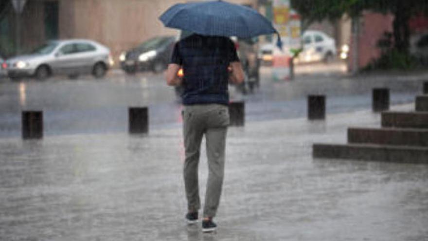 Un hombre camina bajo la lluvia.