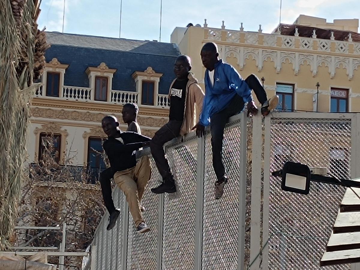 Los cuatro migrantes sobre la valla de la mascletà.