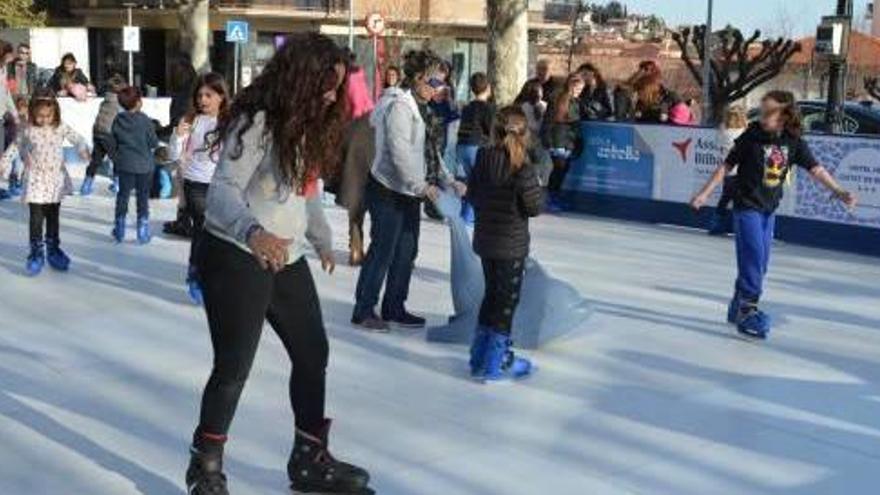 Grups de joves patinant a la pista de gel sintètic instal·lada al Vall
