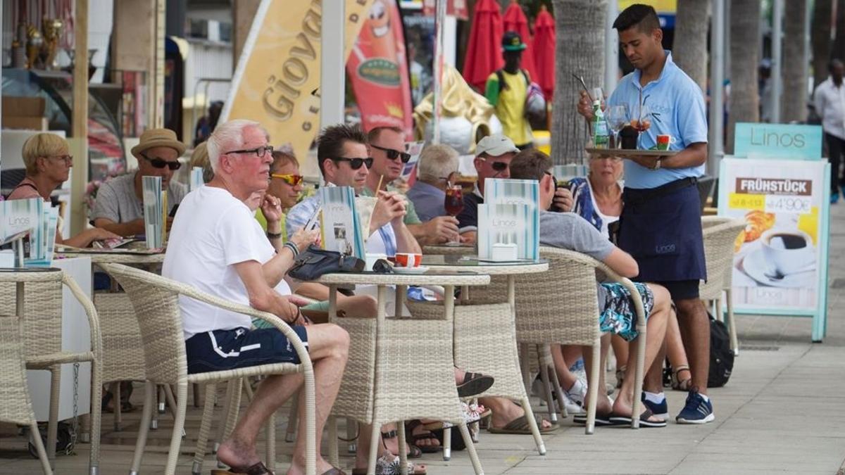 Un camarero atiende a unos turistas en una terraza de Palma de Mallorca.