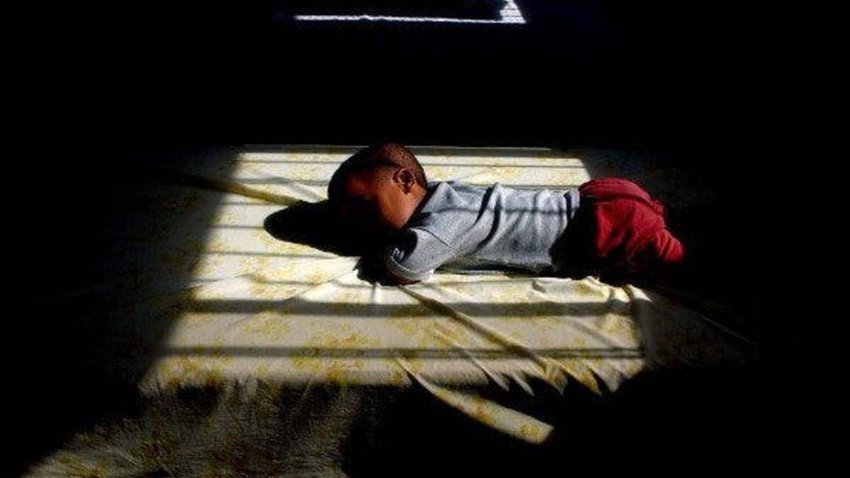 Un niño tumbado en una cama.