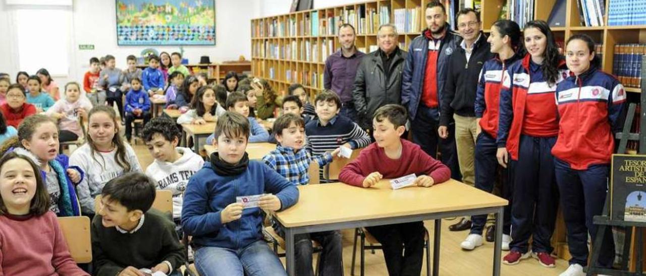 Los directivos y jugadores de la UD Ourense, ayer, con alumnos del CEIP Mestre Vide. // Brais Lorenzo