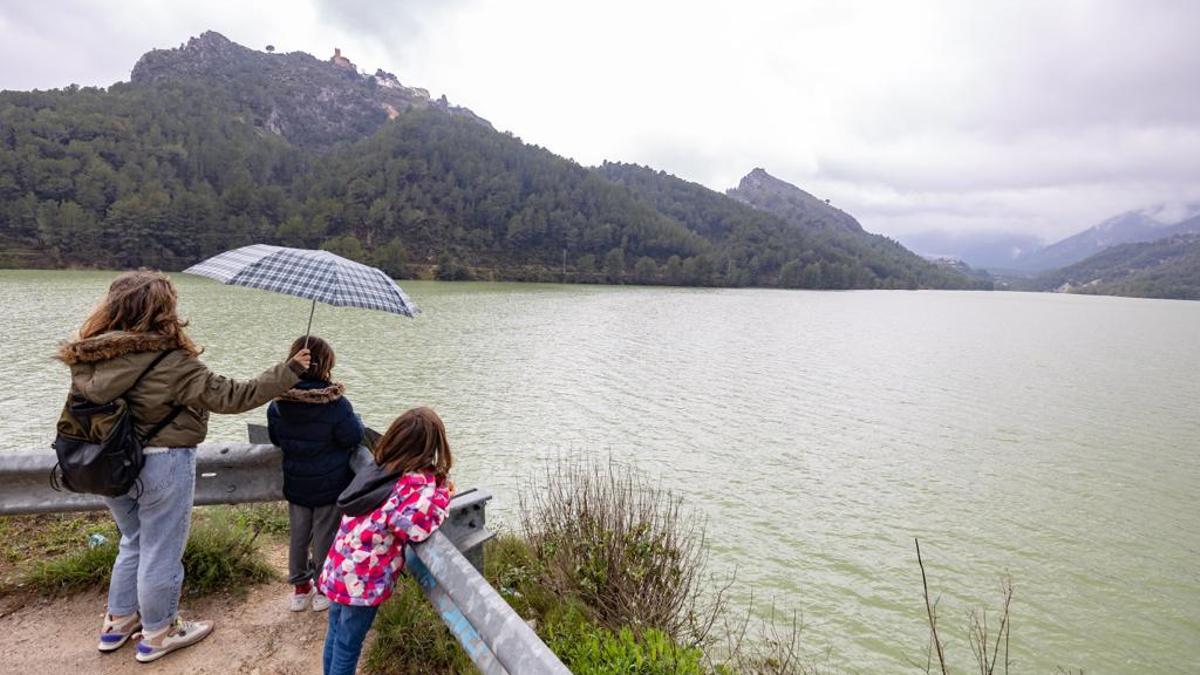 Una mujer observa con dos niñas el impresionante aspecto del embalse de Gualdalest a principios de semana