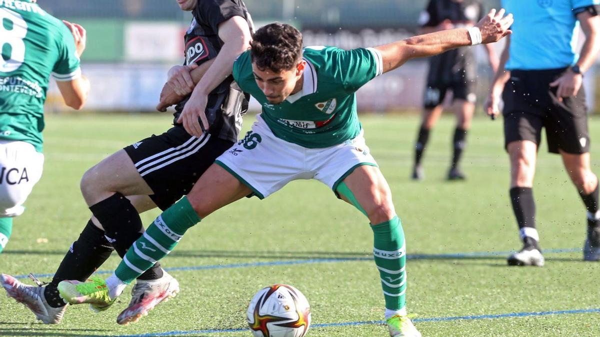 Garci, del Coruxo, protege el balón ante la presión de un jugador del Llanera en el partido disputado en Fragoselo. // MARTA G. BREA