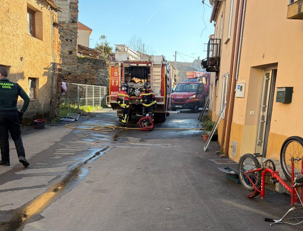 Los bomberos trabajan en la extinción del incendio originado en la vivienda.