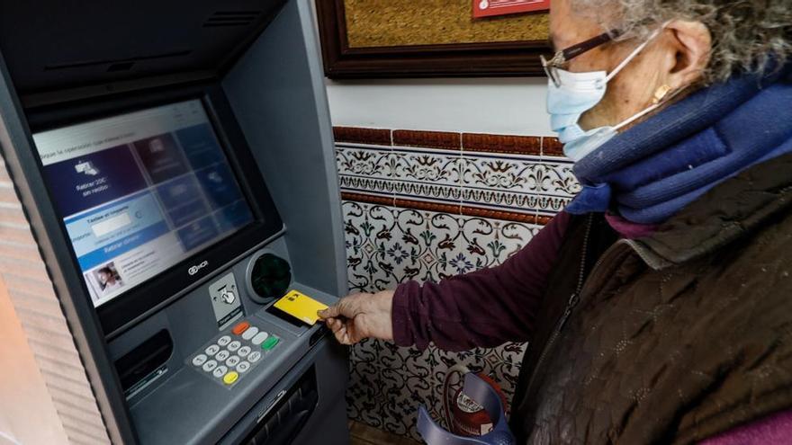 Una vecina de Fageca utilizando el cajero automático que ha instalado la Generalitat en el pueblo.