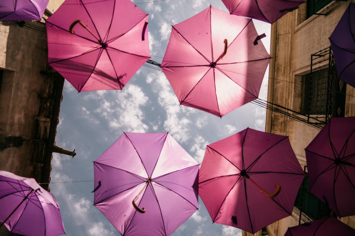 Paraguas de color malva se reparten por las calles principales de Brihuega para amortiguar el sol.