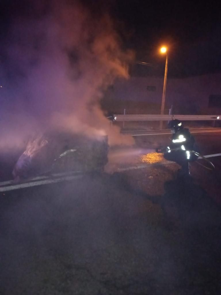 Los bomberos sofocando el fuego de la barricada.