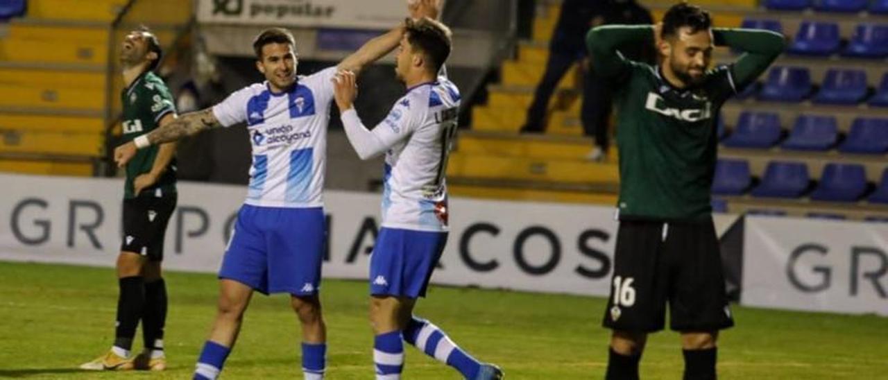 La decepción del jugador del Castellón Kevin Sibille (d) contrasta con la alegría del Alcoyano tras igualar en el minuto 95 con gol en propia puerta del albinegro.
