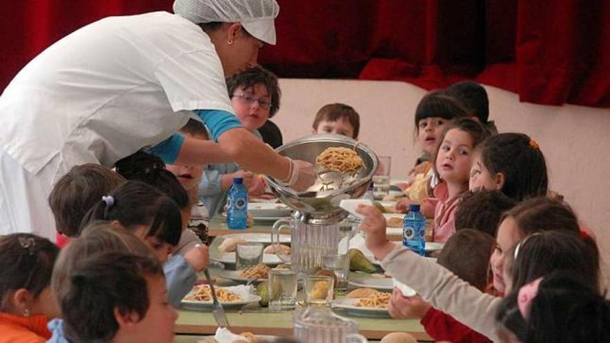 Una monitora sirve a los niños en el comedor de un colegio gallego. / iñaki abella