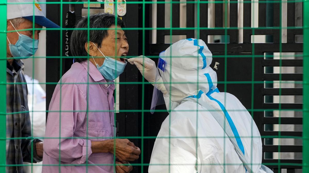 Voluntarios sanitarios hacen un test a una residente de Shanghái